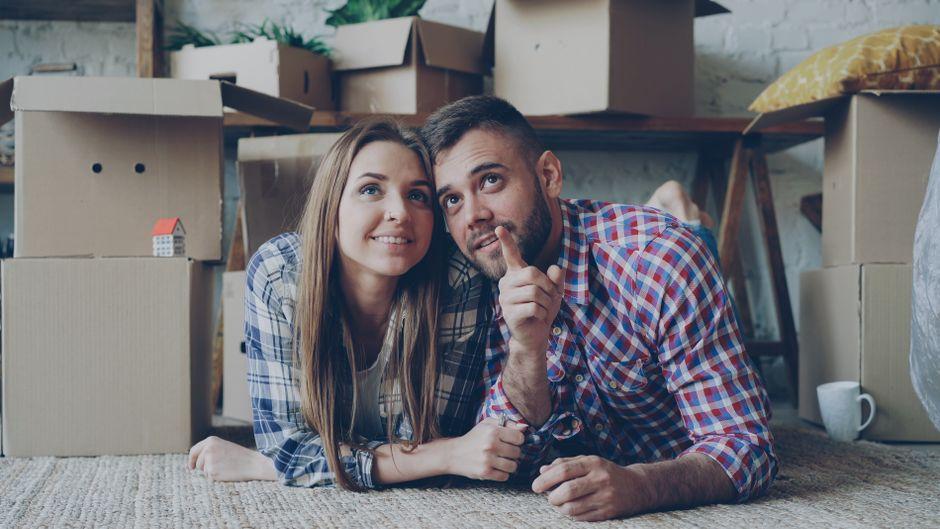 Couple Relaxing in New Home Surrounded by Boxes